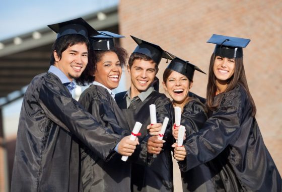 Students In Graduation Gowns Showing Diplomas On Campus graduation-student-money management-the kingdom code-entrepreneur